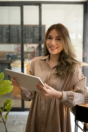 Attractive, smiling restaurant worker holding iPad.