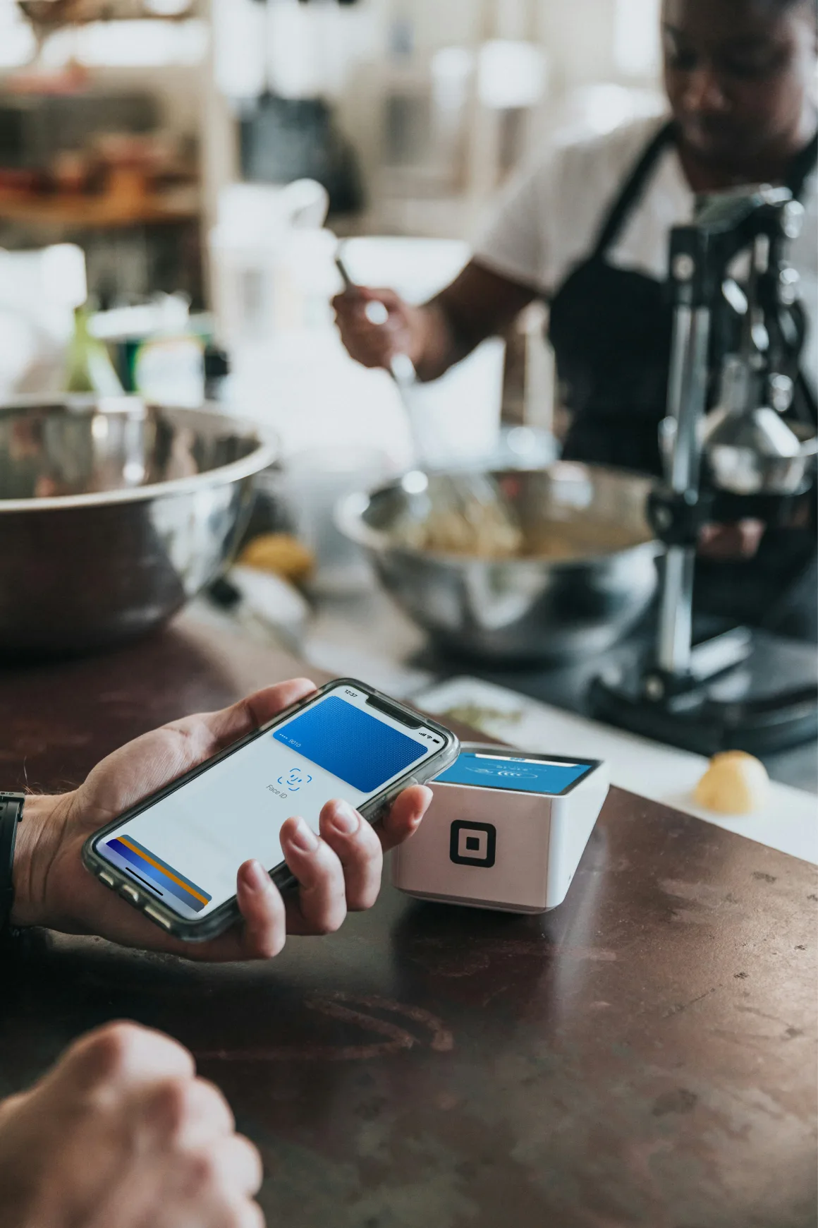 Person paying with their smart phone at a restaurant counter.